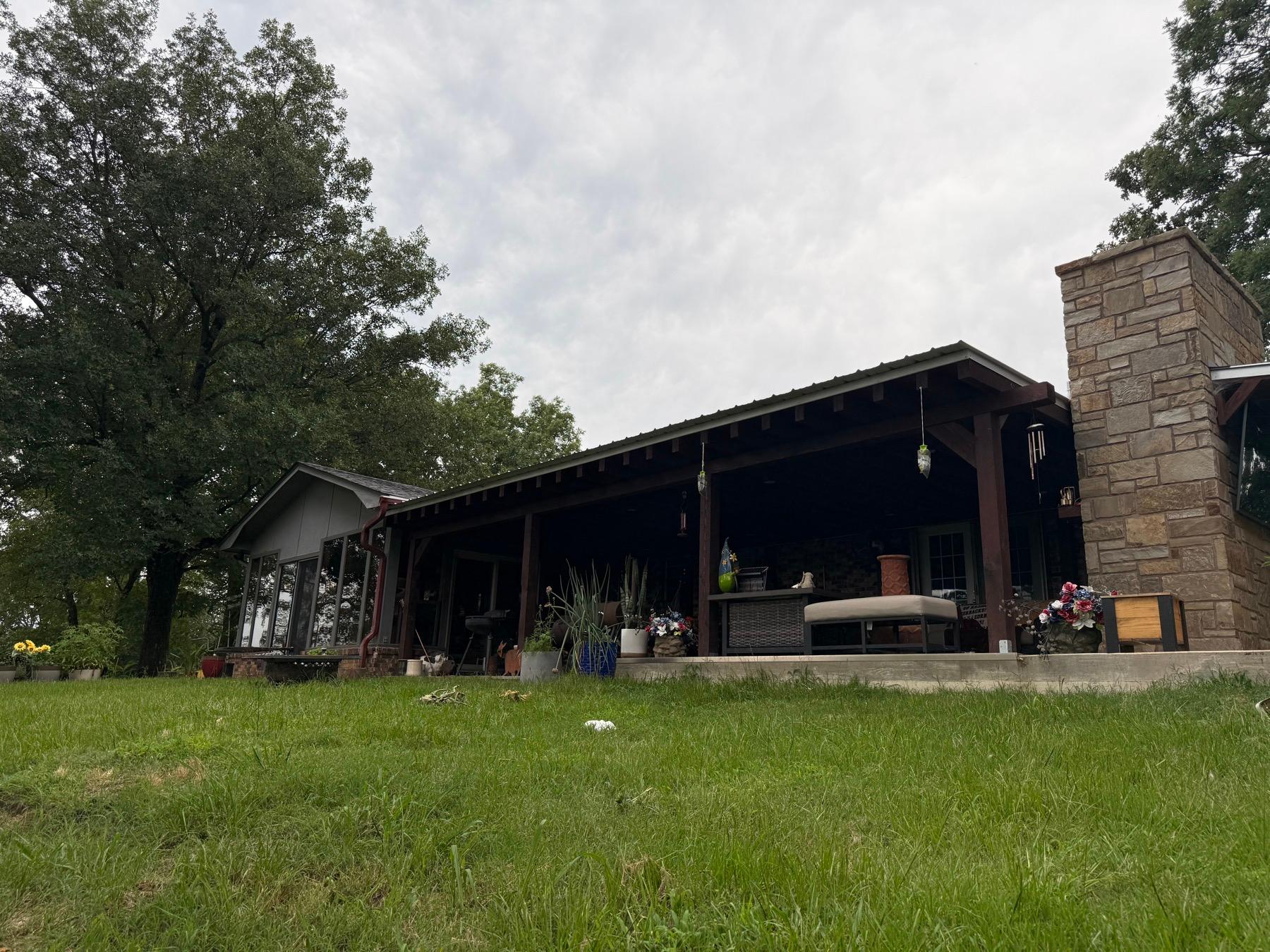 The covered patio and stone chimney at the Garrett Valley Hilltop in Clarksville, Arkansas.